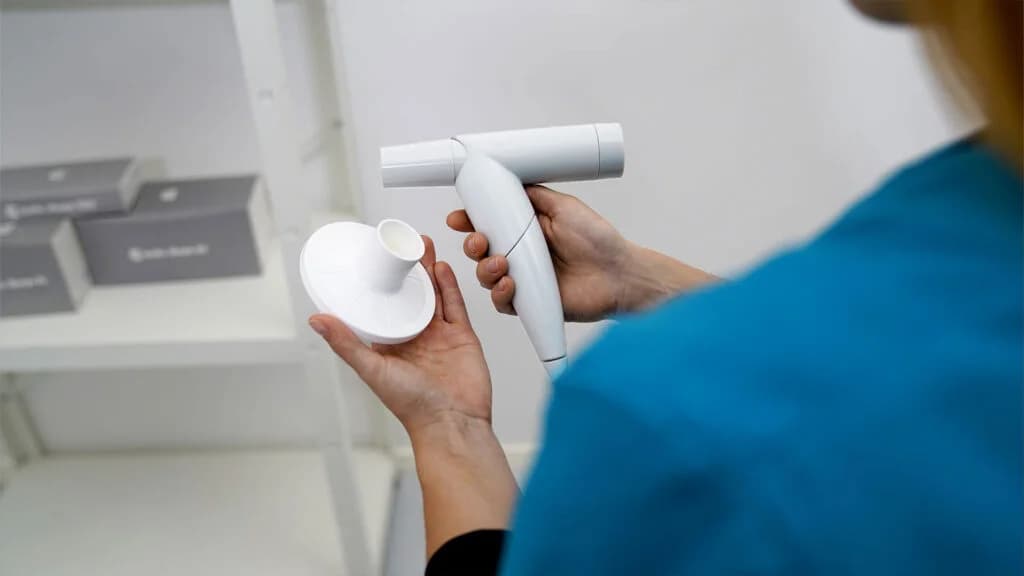custo spiro mobile tenu en main pendant une mesure
