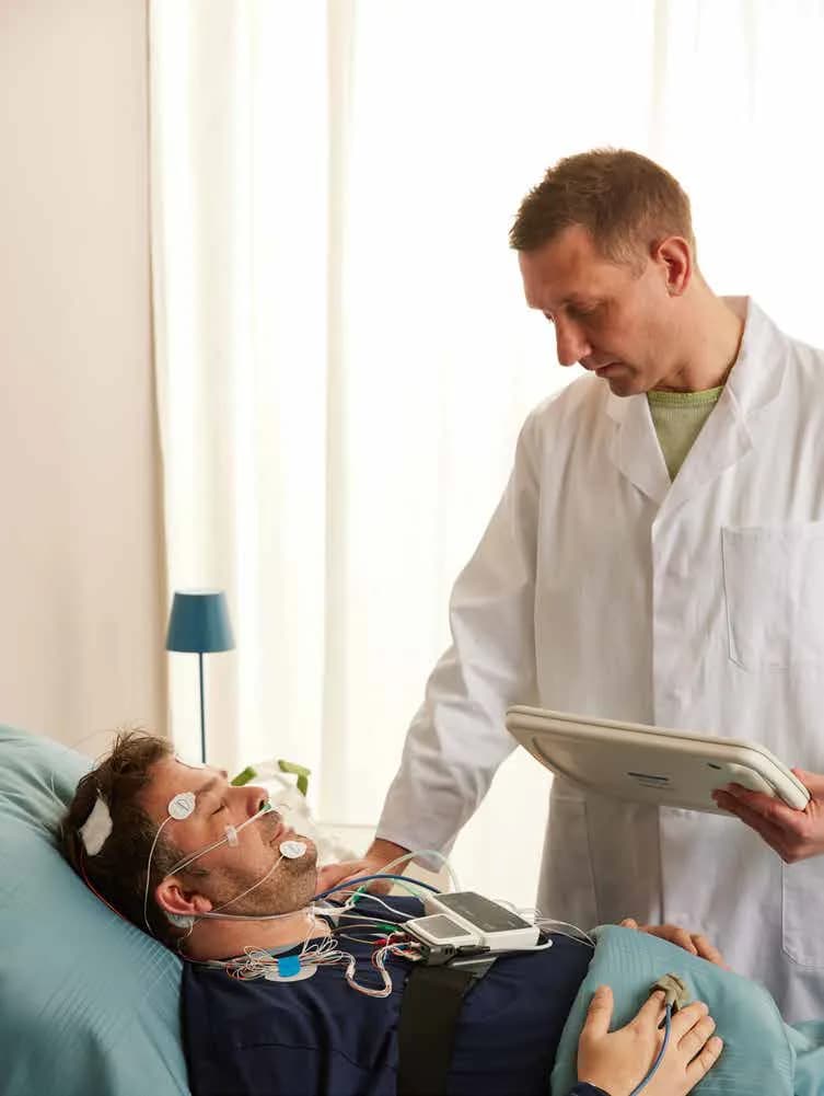 Professionnel contrôlant les signaux d’un examen du sommeil
