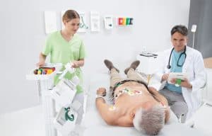 Patient relié aux électrodes MESI mTABLET ECG pendant que le médecin consulte la tablette