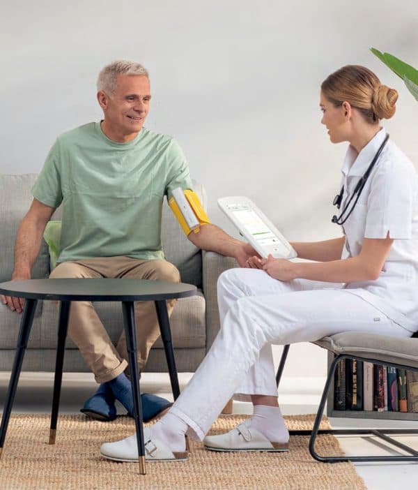 Professionnelle de santé mesurant la tension d’un patient avec le MESI mTABLET BP