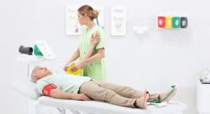 Patient allongé équipé de brassards aux bras et de capteurs aux orteils pour une mesure TBI
