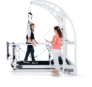 Système d'entraînement à la marche robowalk® : patient âgé marchant sur tapis avec harnais et système robotisé de rééducation