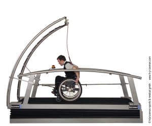 Tapis roulant médical H/P/Cosmos saturn® : utilisateur en fauteuil roulant s’entraînant sur le tapis incurvé avec harnais