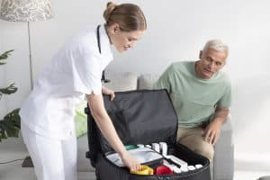 Infirmière ouvrant le sac de transport des modules MESI mTABLET auprès d’un patient