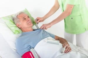 Infirmière utilisant la sonde axillaire du thermomètre MESI mTABLET sur un patient