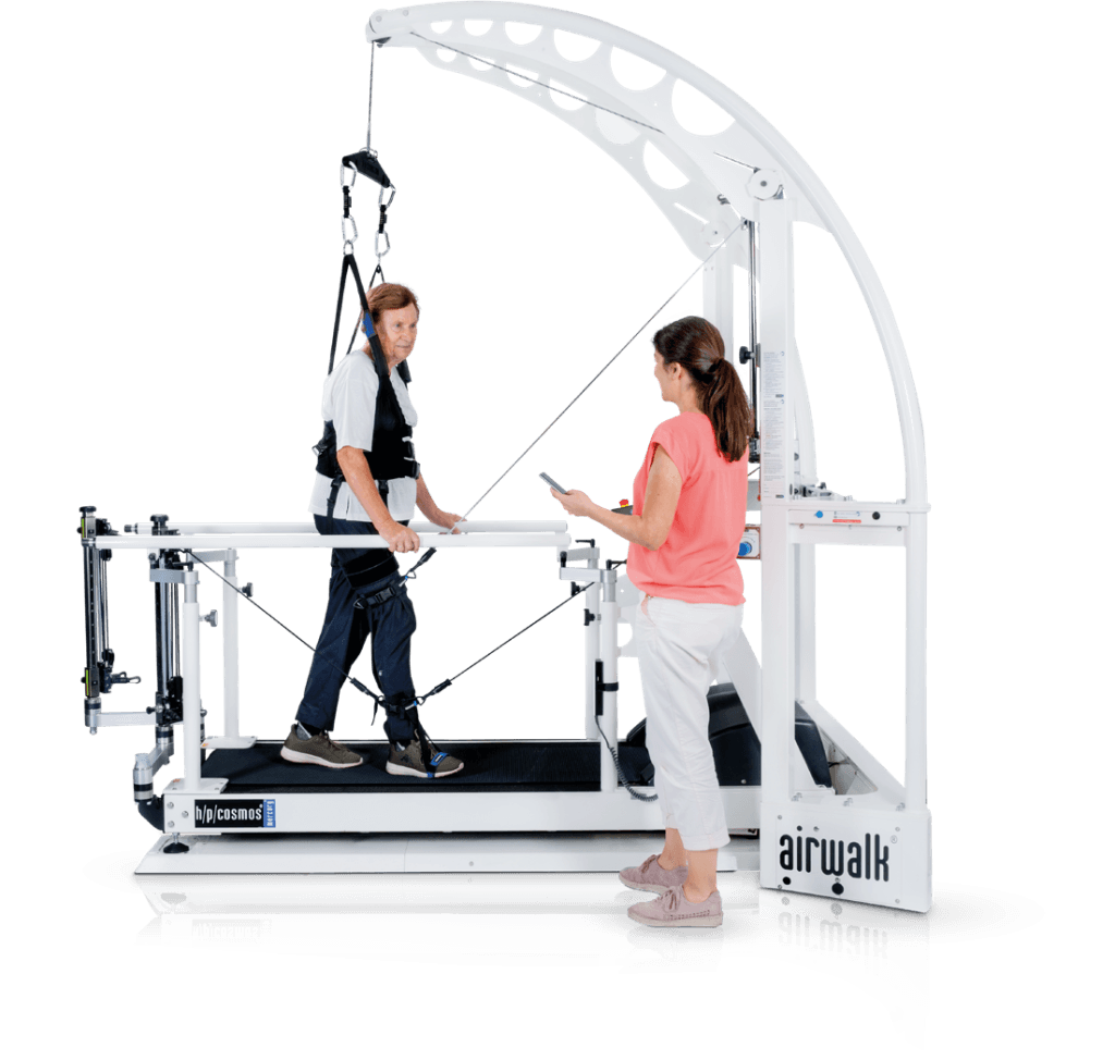 Système d'entraînement à la marche robowalk® : patient âgé marchant sur tapis avec harnais et système robotisé de rééducation